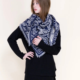 Navy and white paisley triangular scarf with fringe edges worn draped over shoulders
