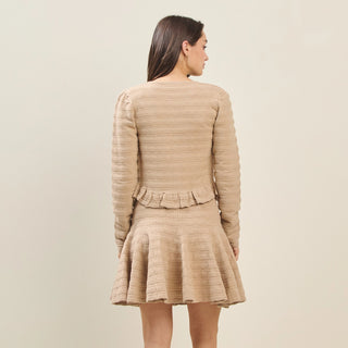 Beige textured long-sleeve cardigan with ruffle hem detail, back view