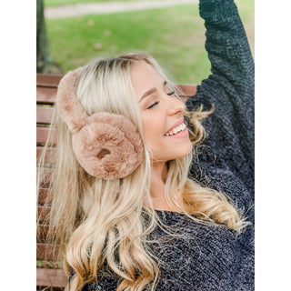 C.C Beanie taupe faux fur earmuffs worn by smiling woman on park bench