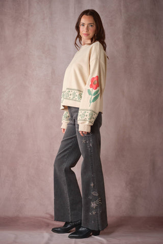 Cream oversized sweatshirt with green paisley trim and red floral graphic on sleeve