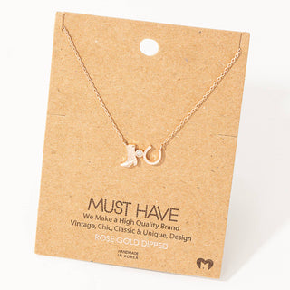 Rose gold cowboy boot and horseshoe charm necklace on kraft paper display card
