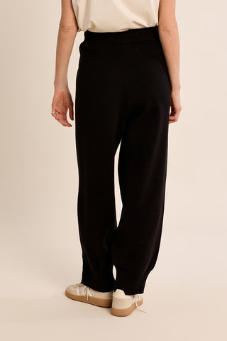 Black knitted wide-leg pants with ribbed cuffs, back view on model