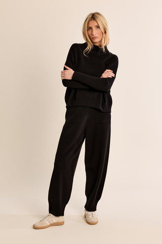 Black knitted wide-leg jogger pants with ribbed cuffs and side pockets