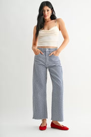 Woman wearing a white top and checkered pants on a plain background