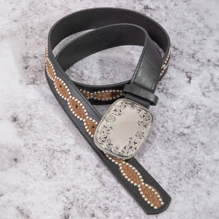 A black leather belt with a decorative brown and white patterned strap and a large engraved silver-tone buckle, displayed on a light gray marbled surface.