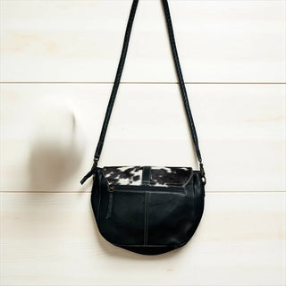 Black leather crossbody bag with black and white cowhide flap and braided strap