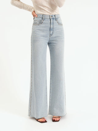 Light blue flared jeans worn by a person on a white background