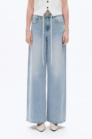 Light blue wide-leg jeans worn by a person on a white background