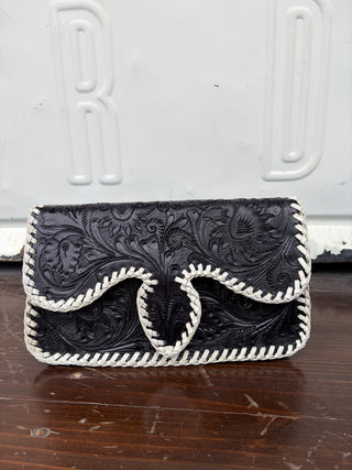 Black tooled leather clutch bag with white braided whipstitch trim and floral embossing