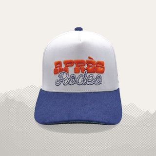 White and blue snapback cap with orange and white embroidered Après Rodeo text