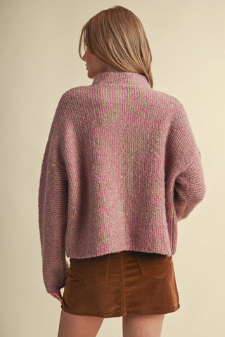 Oversized pink multicolor knit cardigan with mock neck, paired with brown corduroy mini skirt
