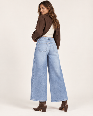 Light blue wide leg denim jeans with back pockets, worn with brown boots