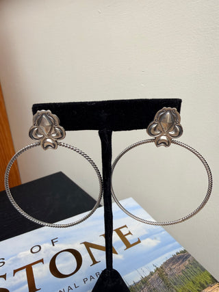 Handmade sterling silver hoop earrings with twisted wire hoops and floral concho studs