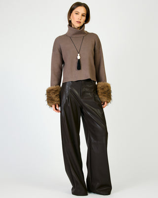 Cropped mocha ribbed turtleneck sweater with faux fur cuffs on female model