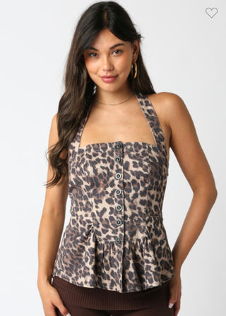 Woman wearing a leopard print top with buttons on a white background