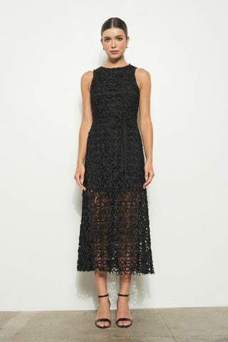 Woman wearing a black lace dress against a white background