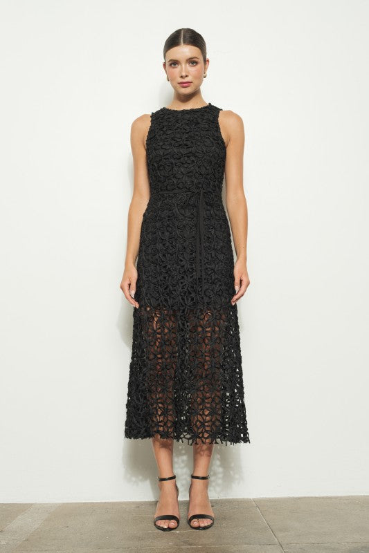 Woman wearing a black lace dress against a white background