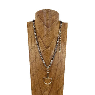 Silver wheat chain necklace with gold-tone horse bit pendant on wooden display bust