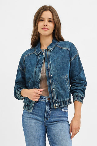 Woman wearing a blue denim jacket and jeans on a white background