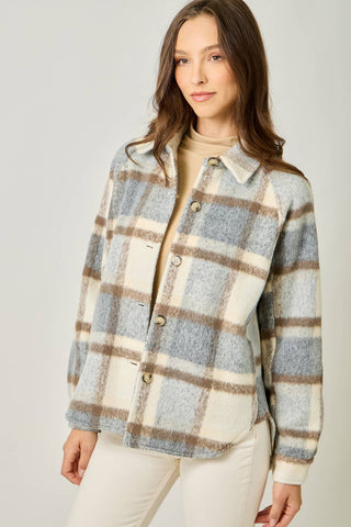 Woman wearing a plaid jacket with a neutral background