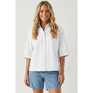 Woman wearing a light blue shirt and denim shorts on a white background