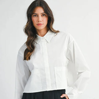 Woman wearing a white blouse against a plain background