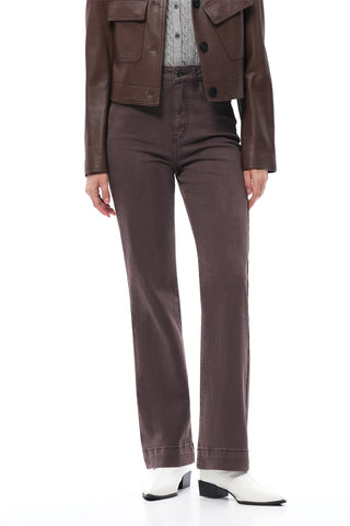 Person wearing a brown jacket and pants with white shoes on a white background