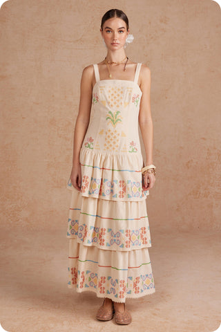 Woman wearing a floral tiered dress against a beige background