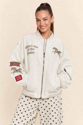 Cream bomber jacket with western horse embroidery, rodeo patches, and zip front