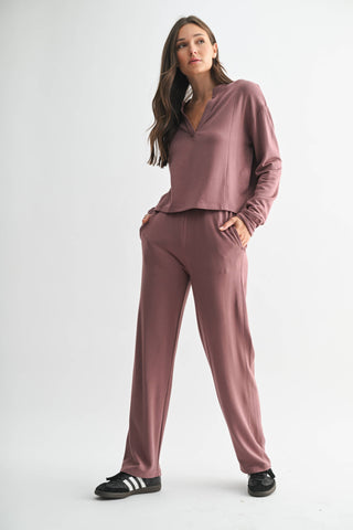 Woman wearing a mauve tracksuit on a white background