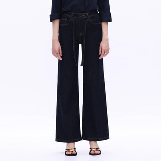 Person wearing black wide-leg jeans on a white background