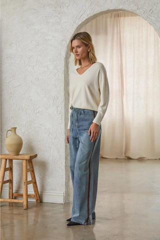 Wide-leg light wash denim pants with contrast side stripe and drawstring waist