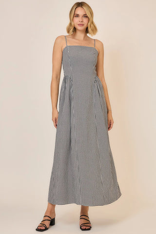 Woman wearing a black and white checkered dress on a beige background