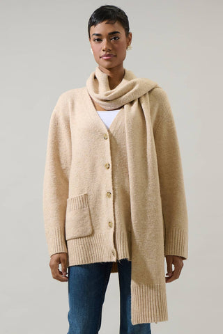 Person wearing a beige cardigan and scarf on a plain background