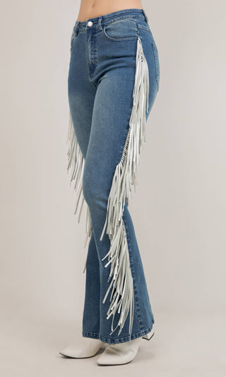 Medium wash blue flare jeans with white side fringe detail and white boots