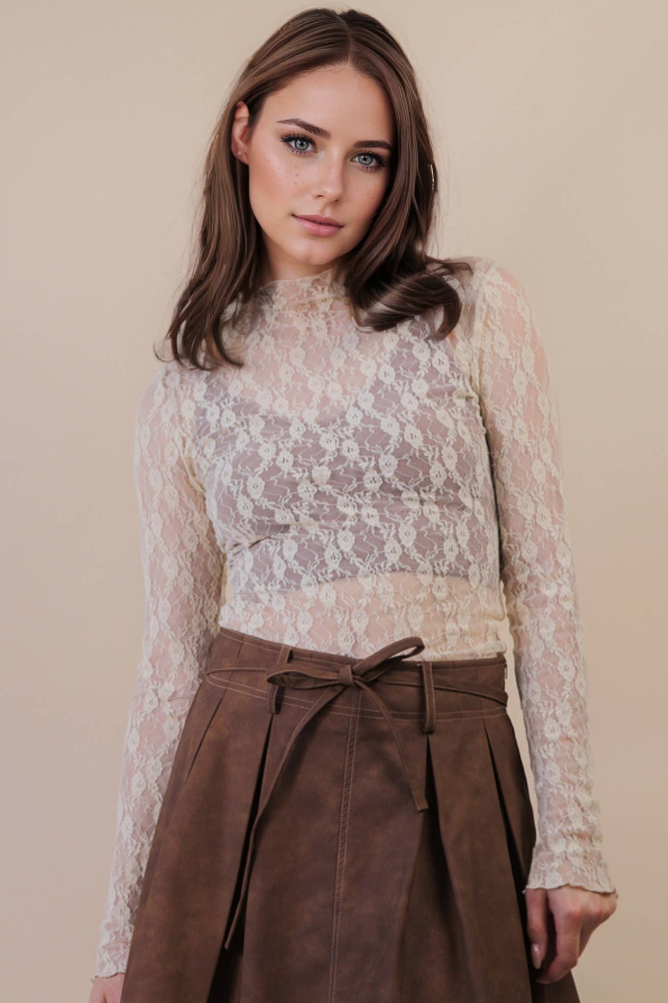 Woman wearing a lace top and brown skirt against a beige background