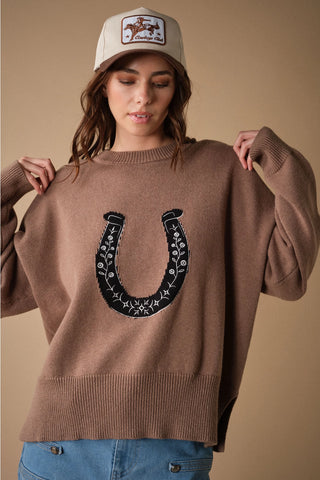 Oversized mocha knit sweater with black floral embroidered horseshoe graphic on front