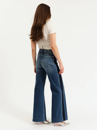 Person wearing blue flared jeans with a white background