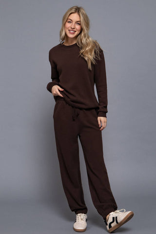 Woman wearing a brown outfit against a gray background