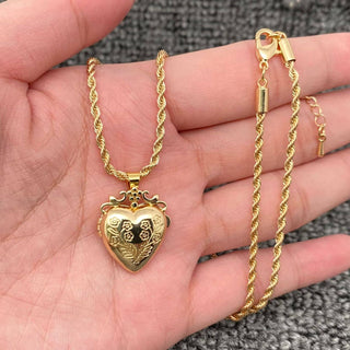 Gold heart-shaped pendant necklace on a hand