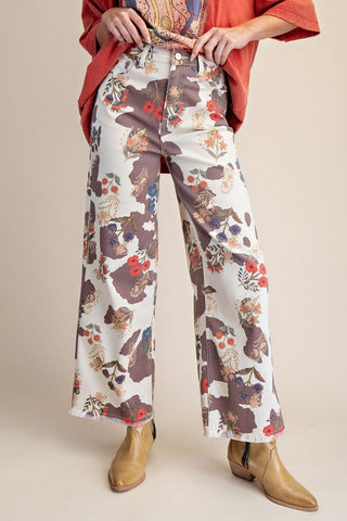 Person wearing floral-patterned pants with a plain background