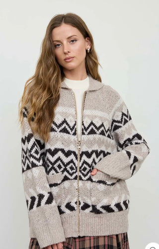 Model wearing a zip-up collared knit cardigan with geometric Fair Isle pattern in neutral tones