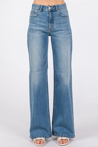 A pair of blue slouchy wide leg jeans with a high waist rise and a leg opening that flares out.