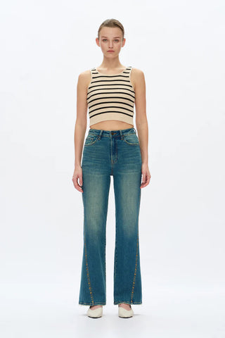 Woman wearing a striped top and blue jeans on a white background