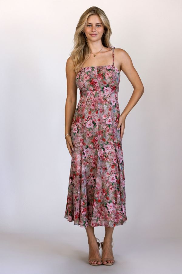 Woman wearing a floral dress against a plain background