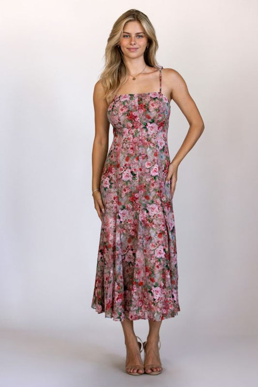 Woman wearing a floral dress against a plain background