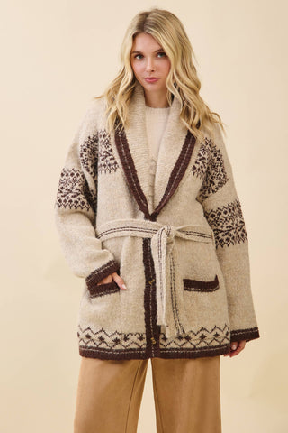 Woman wearing a patterned cardigan against a beige background