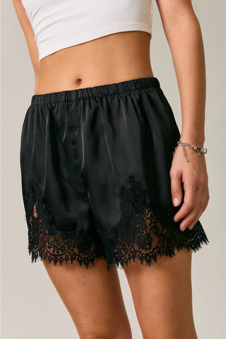 Black satin lounge shorts with floral lace trim hem and elastic waistband
