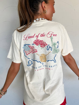 Person wearing a white t-shirt with patriotic graphics and text.