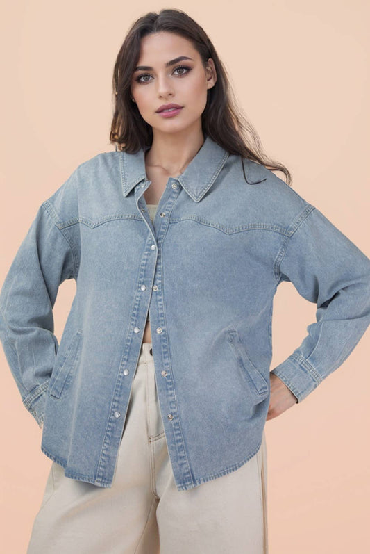 Woman wearing a light blue denim jacket against a beige background